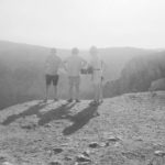 Black and white photo of four people looking at monuntains