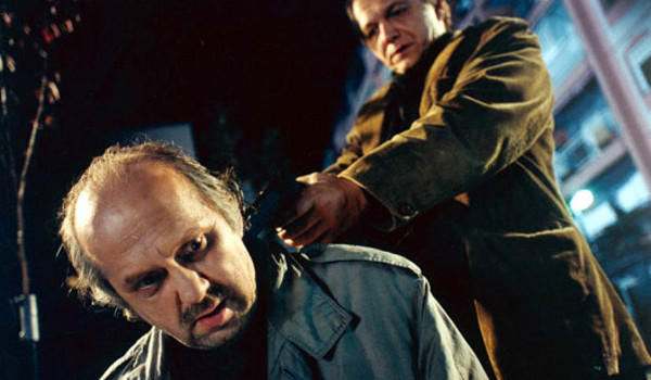 Scene from a film - guy pointing a gun into other guy's head